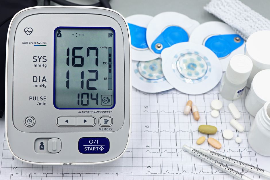 A blood pressure monitor next to oxycodone pills, illustrating the connection between opioid use and low blood pressure