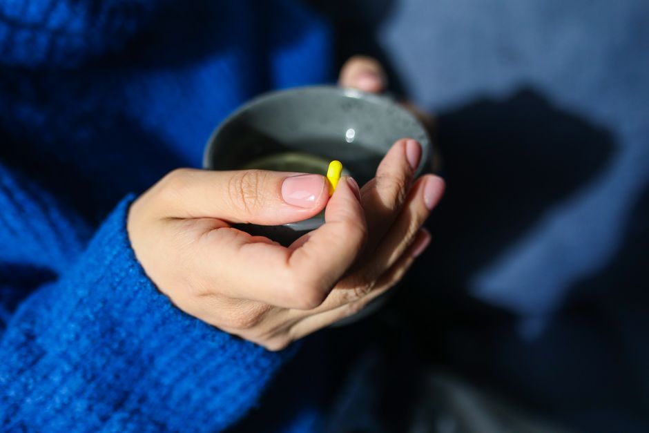 A cup of coffee next to oxycodone pills on a table, illustrating drinking coffee with oxycodone