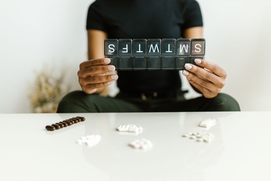 A person considering whether they can fast while taking oxycodone, with water and pills on a table