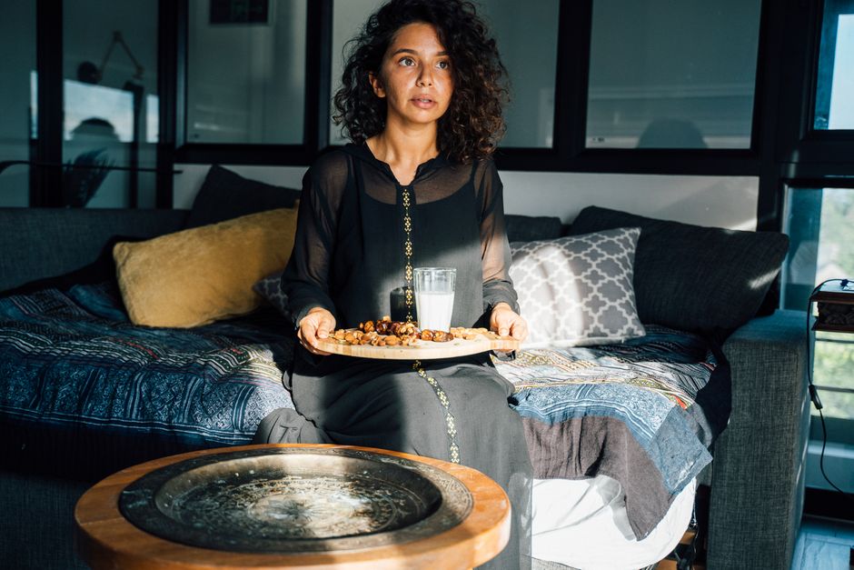 A person preparing to take oxycodone medication alongside a Ramadan iftar meal at sunset
