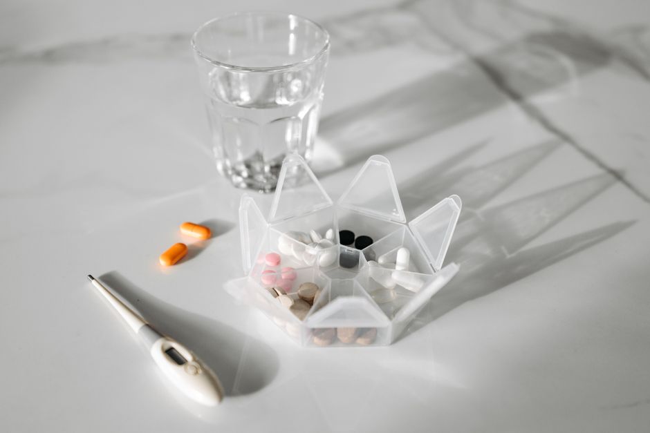 A pill splitter cutting a white tablet in half on a countertop
