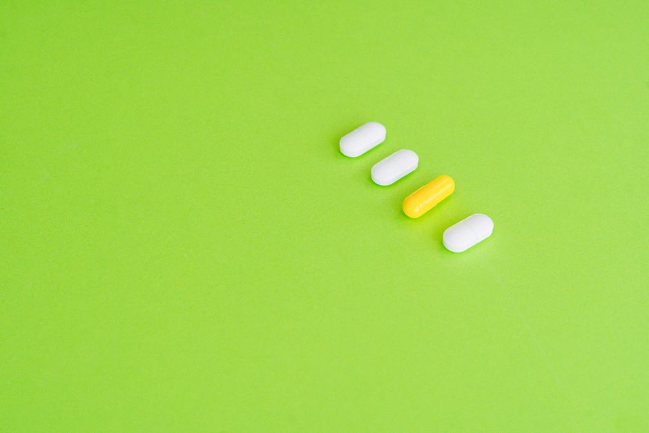 Assorted vitamin supplements and pill bottles next to a prescription medication bottle