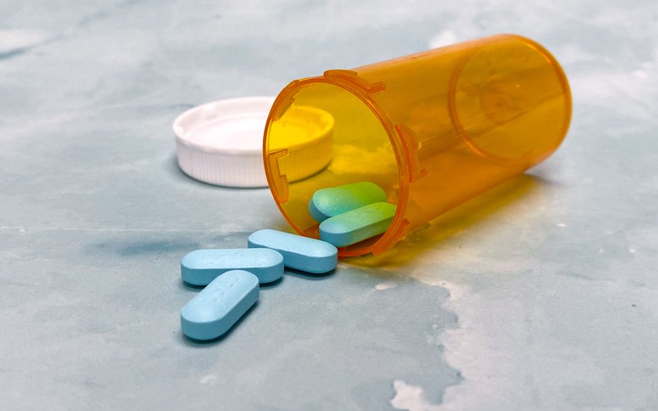 Benadryl antihistamine tablets next to an oxycodone prescription bottle illustrating potential drug interaction risks