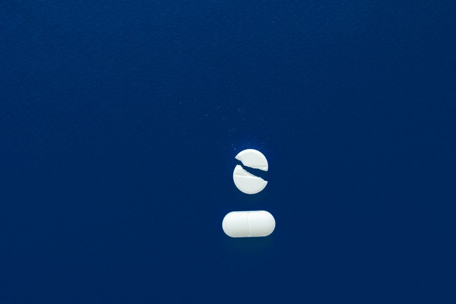 Bottle of oxycodone pills next to a glass of alcohol illustrating dangerous drug interaction risks
