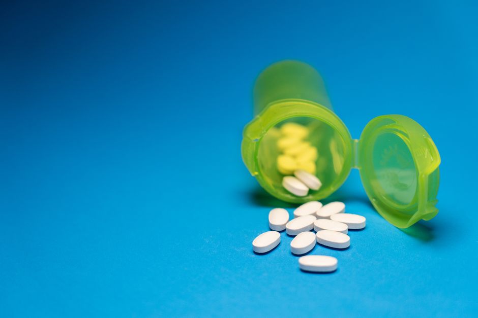 Bottles of oxycodone and Percocet pills next to a prescription label, illustrating the comparison between the two pain medications