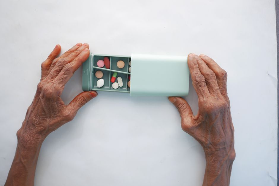 Caregiver helping an older adult manage hydrocodone medication safely at home