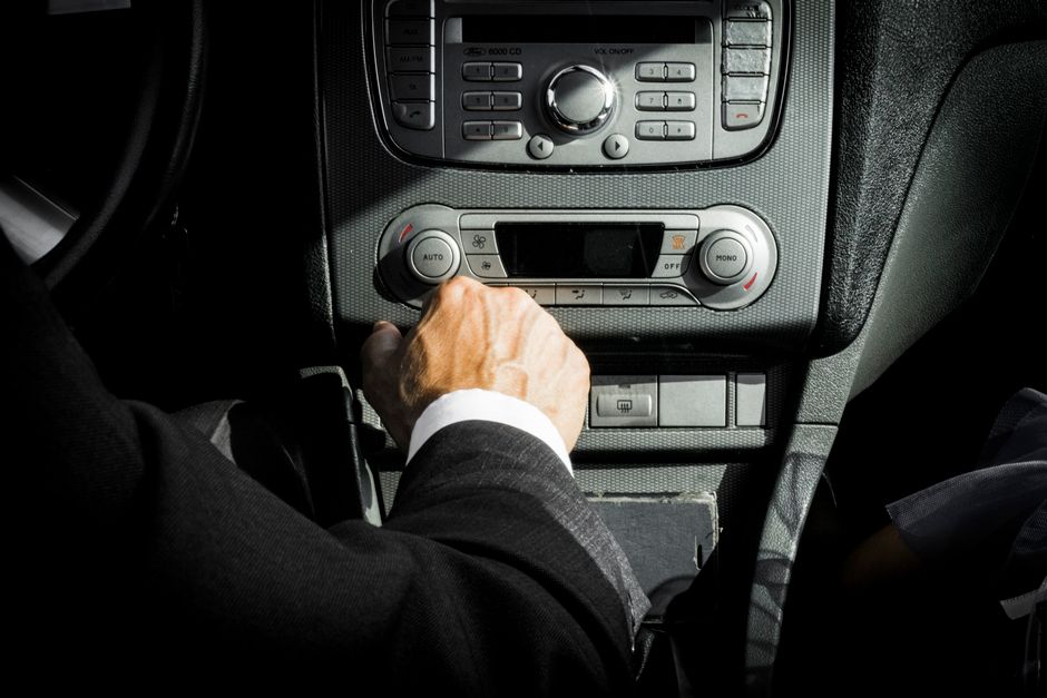 Driver holding a steering wheel with prescription pill bottle nearby, illustrating hydrocodone and driving safety concerns