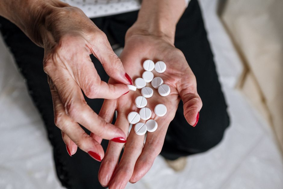 Elderly senior carefully reviewing oxycodone medication with a caregiver for safety
