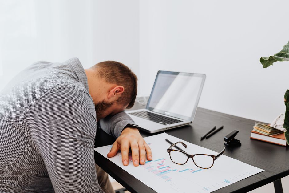 Employee at a desk looking fatigued while returning to work during oxycodone treatment