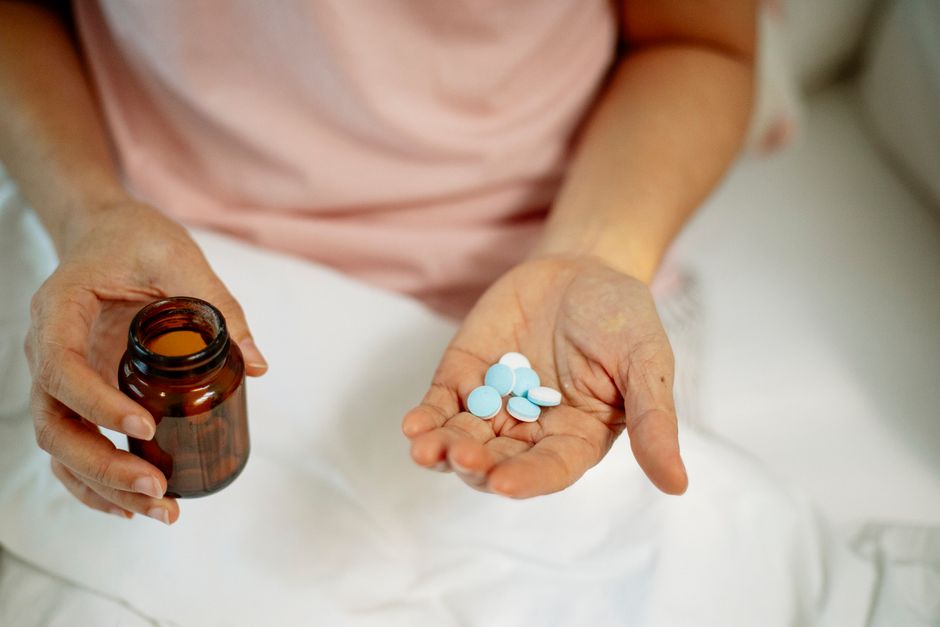 Patient looking anxious while holding an oxycodone pill bottle at home