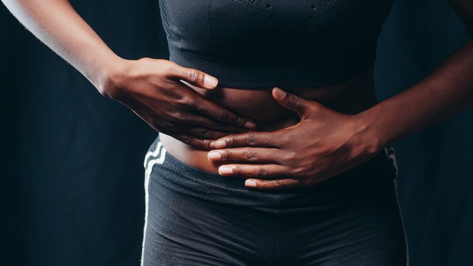 Person experiencing abdominal discomfort from opioid-induced constipation while taking oxycodone