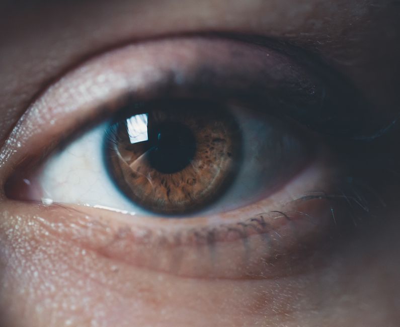 Person experiencing blurred vision while holding a bottle of oxycodone medication