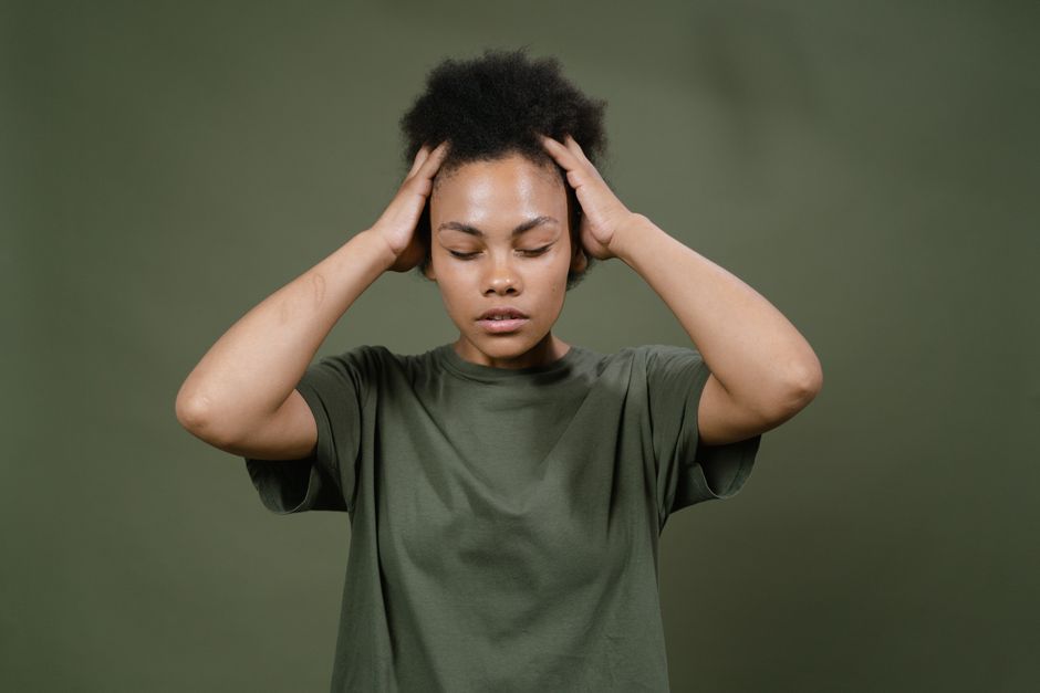 Person experiencing dizziness while holding their head, illustrating a common oxycodone side effect