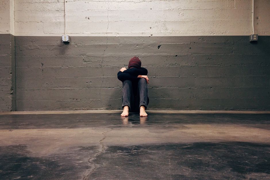 Person sitting on bed experiencing hydrocodone withdrawal symptoms during recovery