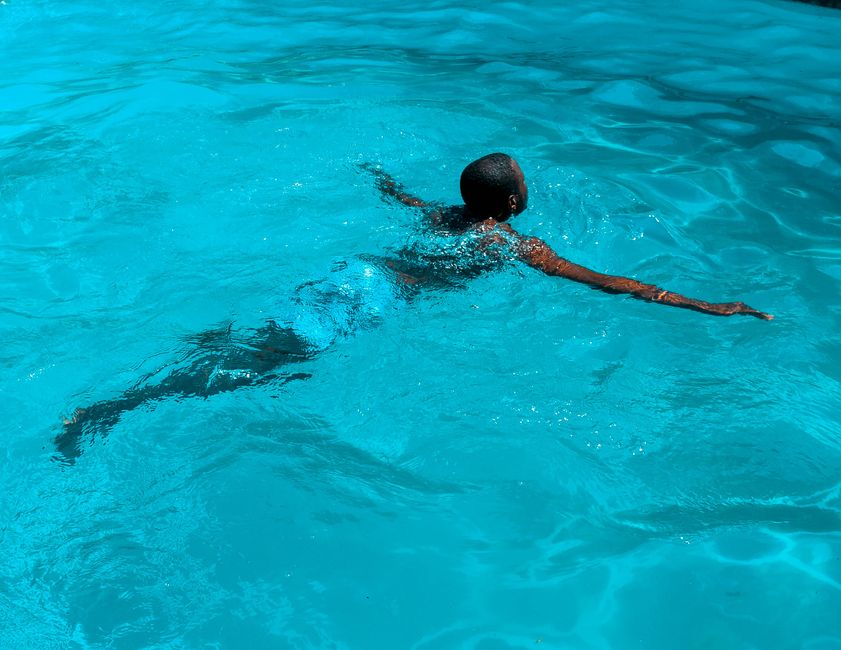 Person swimming in a pool while considering safety precautions related to taking oxycodone