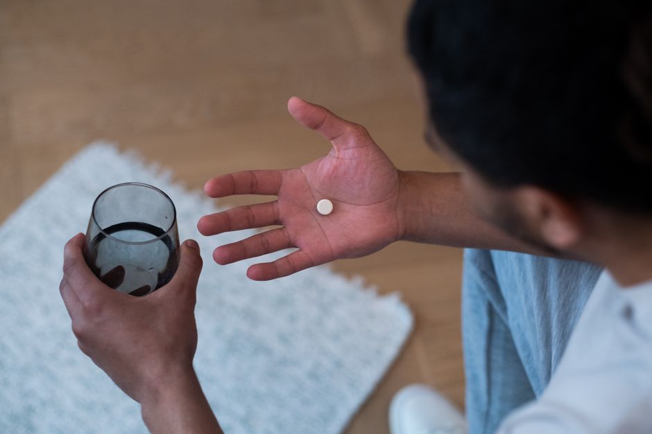Person wiping sweat from forehead, illustrating oxycodone-related sweating side effect