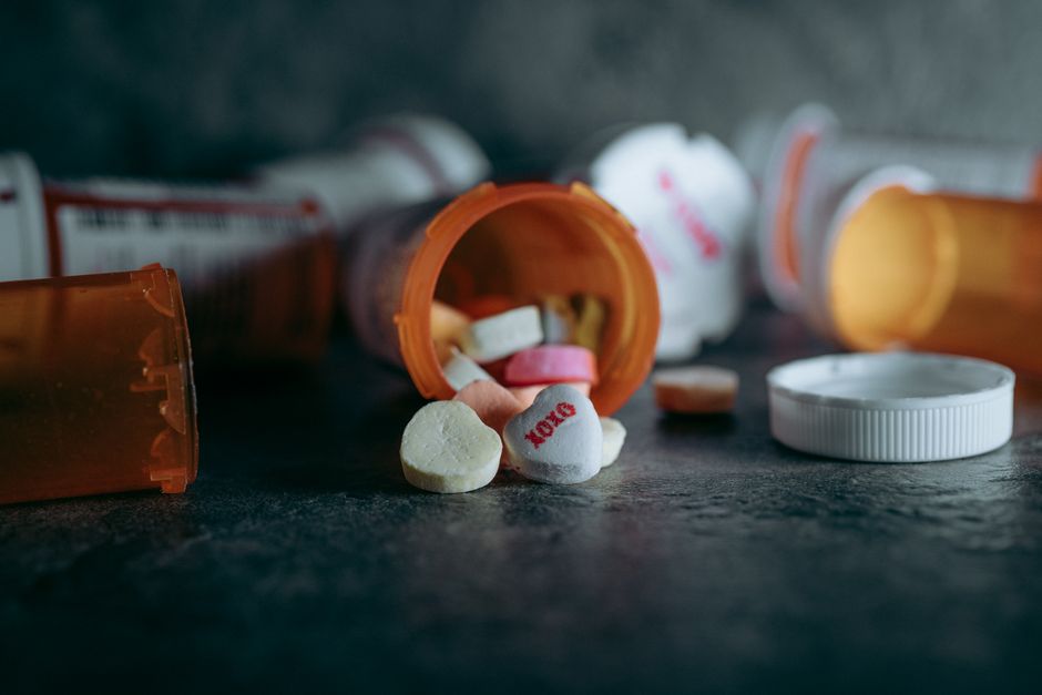 Pharmacist handing an oxycodone prescription bottle to a patient in a Texas pharmacy