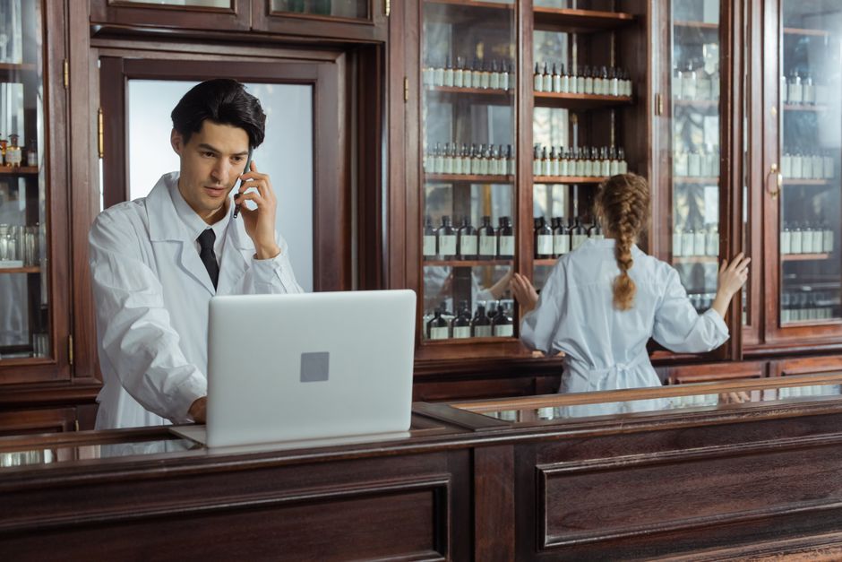 Pharmacist reviewing an oxycodone patient handbook with a patient in a pharmacy setting