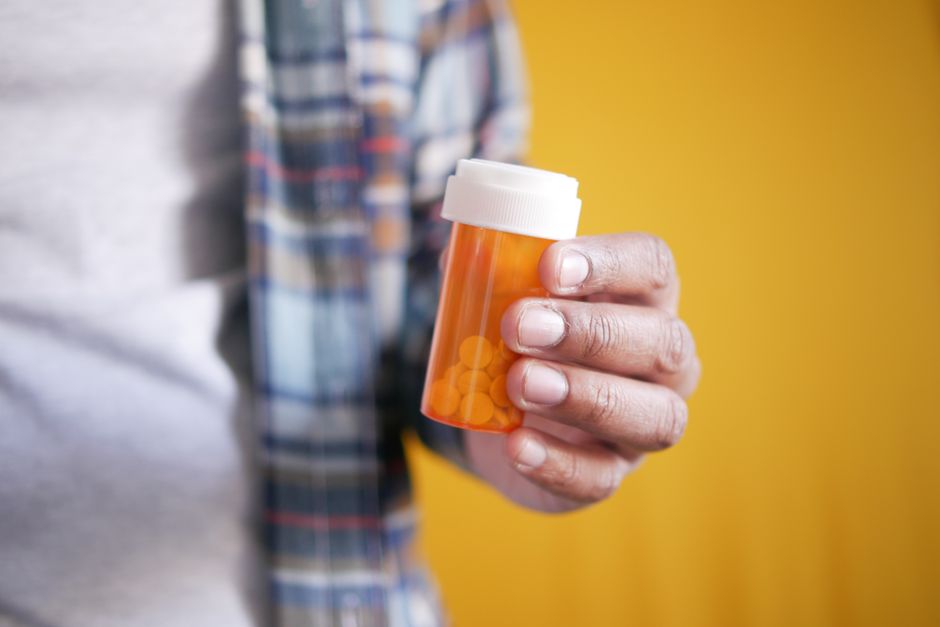 Pharmacist reviewing an oxycodone prescription bottle at an Illinois pharmacy counter