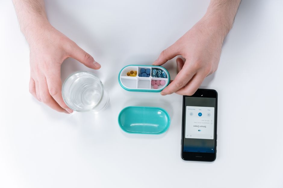 Pill organizer and clock representing a missed oxycodone dose schedule