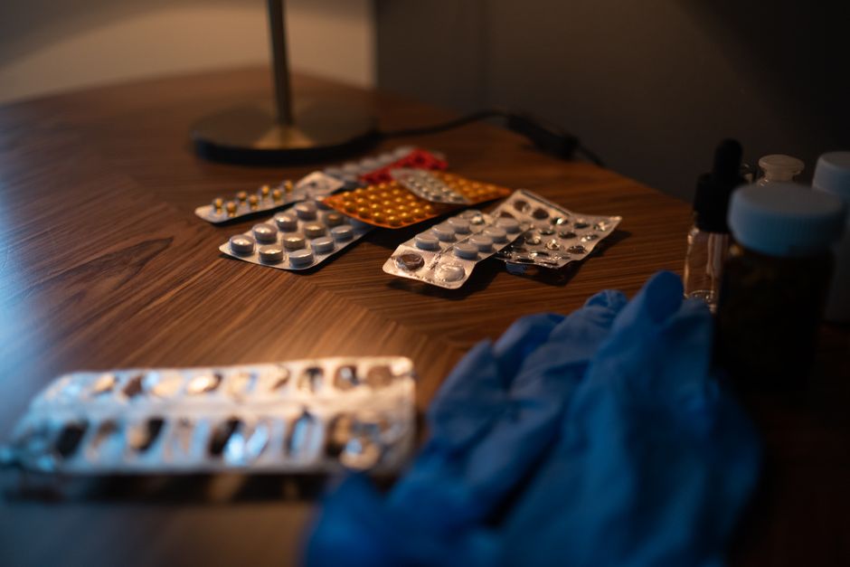 Prescription oxycodone bottle next to sleep medication on a nightstand representing drug interaction risks