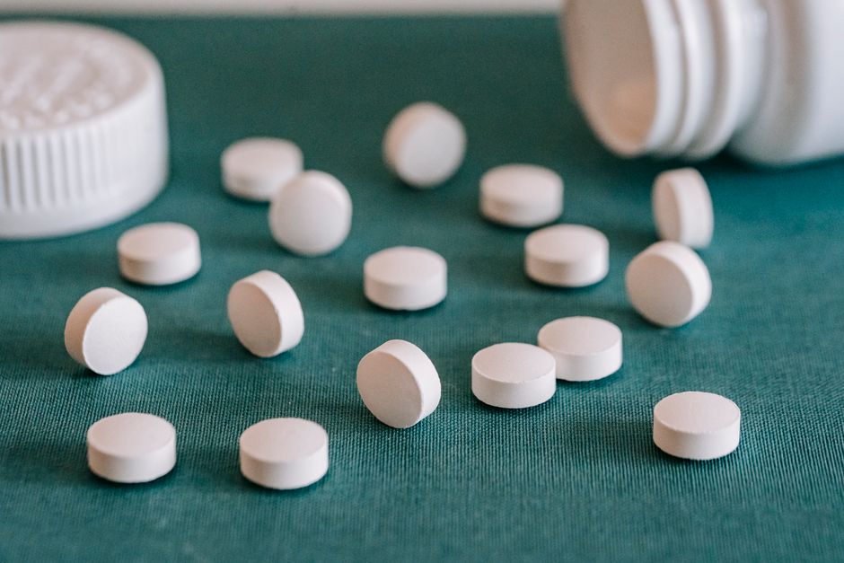 Spilled oxycodone pills next to a prescription bottle representing accidental double dosing
