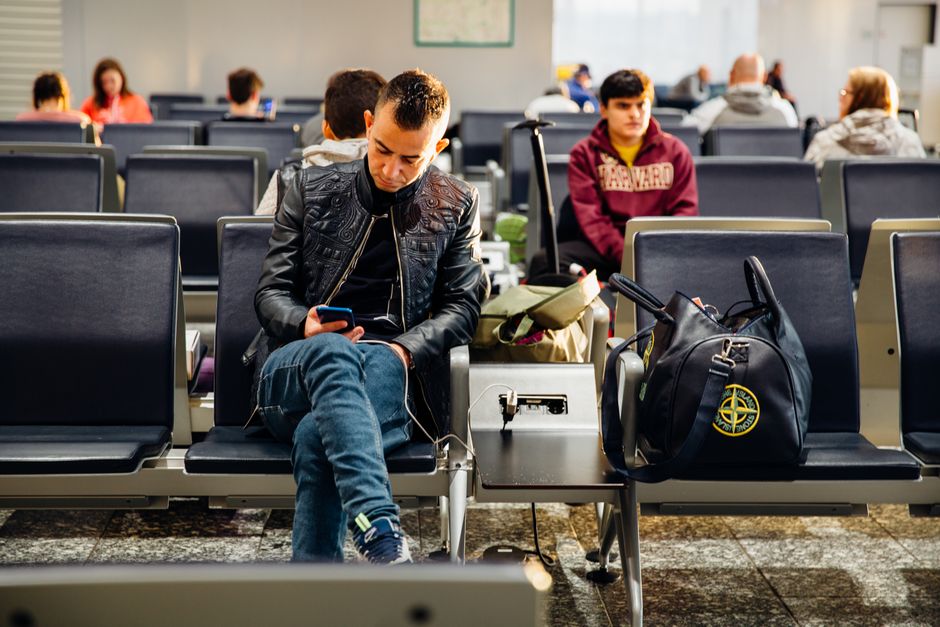 Traveler packing prescription medication bottle into carry-on bag before a flight