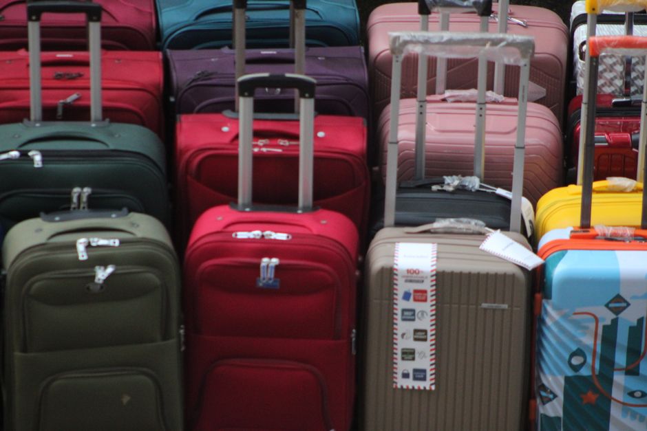 Traveler packing prescription medication bottles into a suitcase before a trip