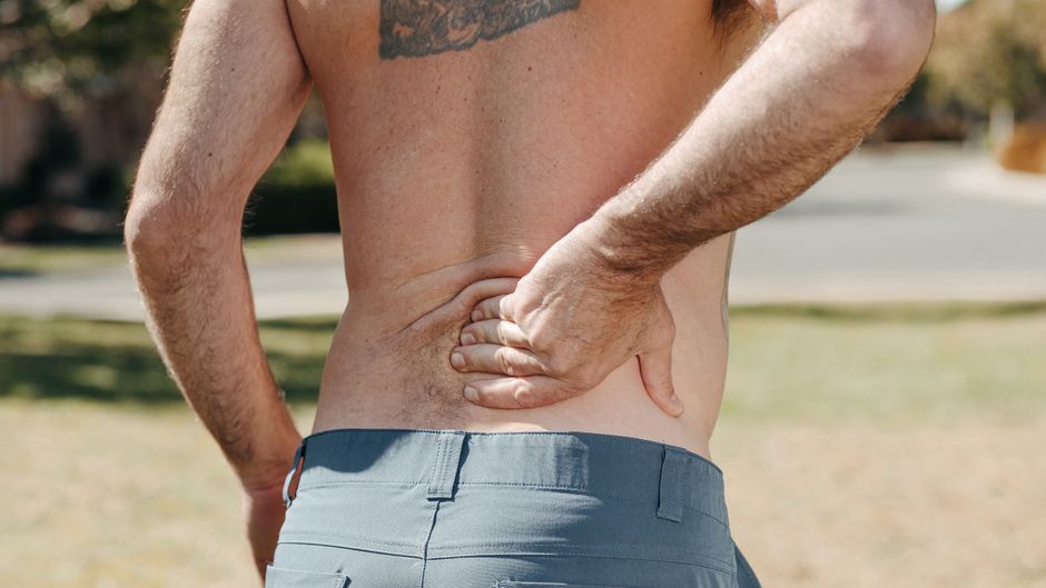 Man holding his lower back in pain, illustrating hydrocodone use for back pain relief