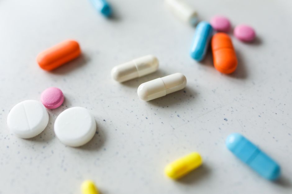 Person holding hydrocodone pills while experiencing nerve pain in their hand