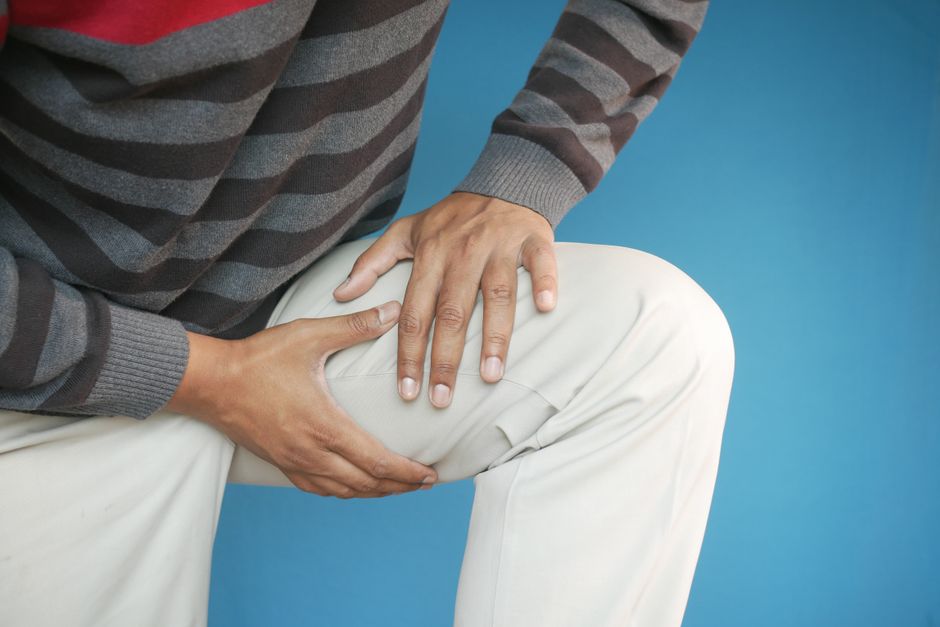 Person holding hydrocodone pills while managing arthritis joint pain